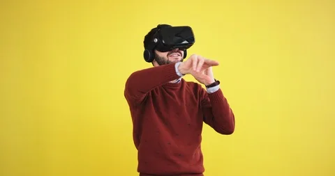 Good looking guy using a VR happy he touching virtual the program to select what Stock Footage 103289360