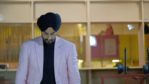 Good looking handsome Sikh man folding his arms in front and then looks at the c Stock Footage 102419432