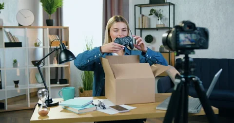 Good-looking happy satisfied young blond female blogger recording unpacking Stock Footage 158485114