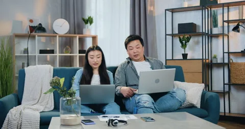 Good-looking happy smiling modern asian father and daughter sitting together on Video stock 151152867