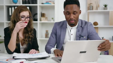 Good-looking high-spirited confident young businesswoman and black-skinned Stock Footage 132211258