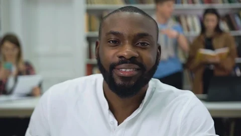 Good-looking high-spirited positive bearded young black-skinned man looking at Stock Footage 125481879