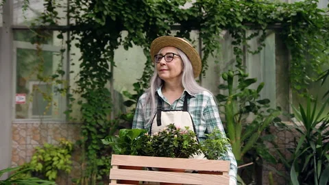 Good-looking high-spirited satisfied grey-haired woman in hat passing through Stock Footage 132559180