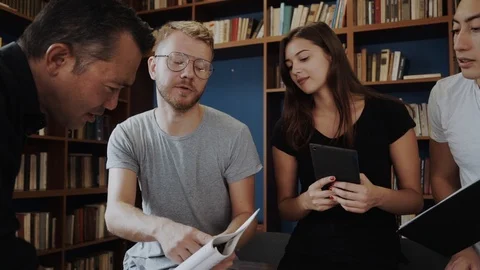 Good looking intenrational students are happy about hteir meeting with a tutor. Stock Footage 98556239