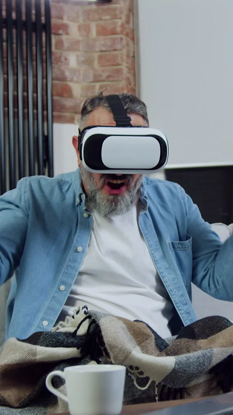 Good-looking joyful 50-aged satisfied bearded man using augmented reality goggle Stock Footage 329677600