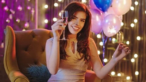 Good looking lady with a large smile at the Christmas party while holding Stock Footage 122042974