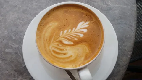Good looking latte coffee on the table at cafe. Zoom-in to hot coffee slowly. Stock Footage 121887563