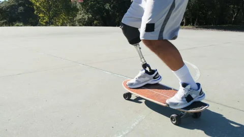 Good-looking man with leg prosthesis skateboarding Stock Footage 226938542