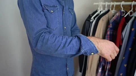 Good-looking man is rolling up shirt sleeves Stock Footage 147900719