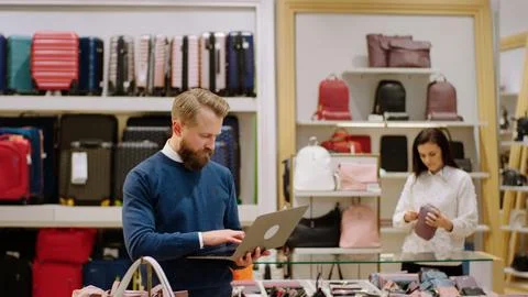 Good looking man supervisor using laptop to verify the price of bags from the Stock Photos