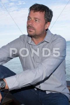 Good looking man wearing white clothes by the sea Stock Photos