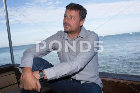 Good looking man wearing white clothes by the sea Stock Photos