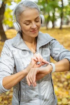 Good-looking mature lady using a fitness device Stock Photos