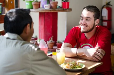 Good looking men having lunch in an outdoor restaurant, men chatting Stock Photos