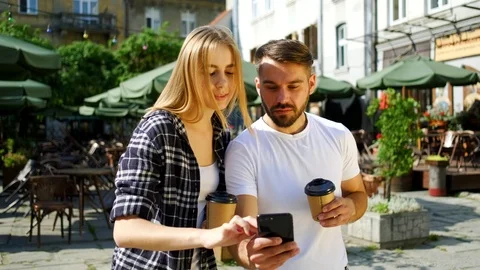 Good-looking modern 30-aged youth standing near street cafe and watching on guy' Stock Footage 112352710