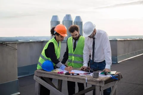 Good looking multiethnic group of workers in a modern building construction site Stock Photos