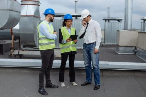Good looking multiethnic group of workers in a modern building construction site Stock Photos