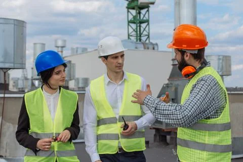 Good looking multiethnic group of workers in a modern building construction site Stock Photos