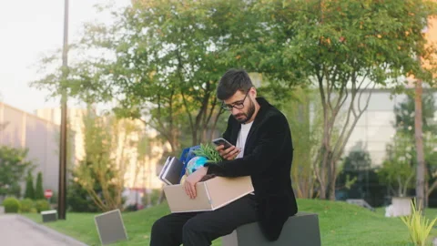 Good looking office manager young man very sad was fired from work he take a sit Stock Footage 194419921