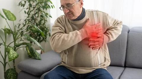 Good looking old man having chest pain heart attack or cardiac arrest with red Fotos de archivo