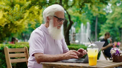 Good looking old man take his laptop at the cafe and working concentrated he Stock Footage 160499097