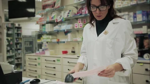 Good looking Pharmacist woman checking prescription medicines at the pharmacy Stock Footage 46989964