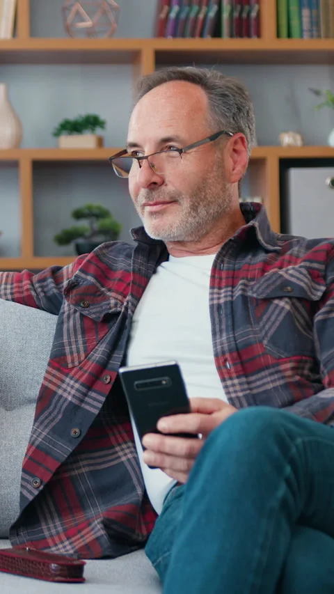 Good-looking positive relaxed bearded man in casual clothes wears eyeglasses sit Stock Footage 328033900