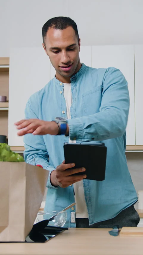 Good-looking positive tanned guy in casual clothes checks the ordered food accor Vídeos de archivo 328304507