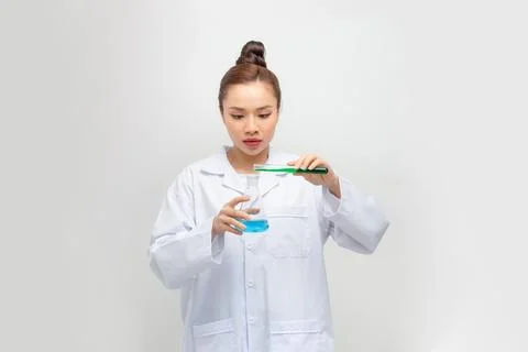 Good looking scientist looking at a test tube in a lab Stock Photos