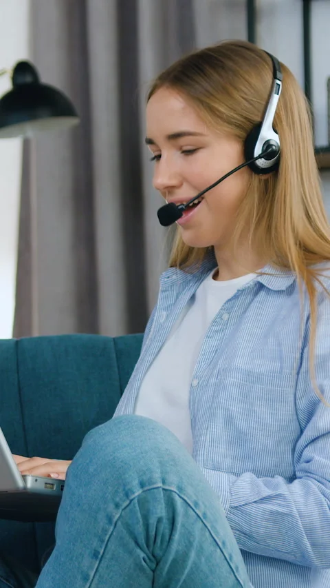 Good-looking smiling confident 20-aged female student in headphones sitting on c Stock Footage 331438222