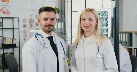 Good-looking smiling experienced successful adult male and female medics in Stock Footage 160424904