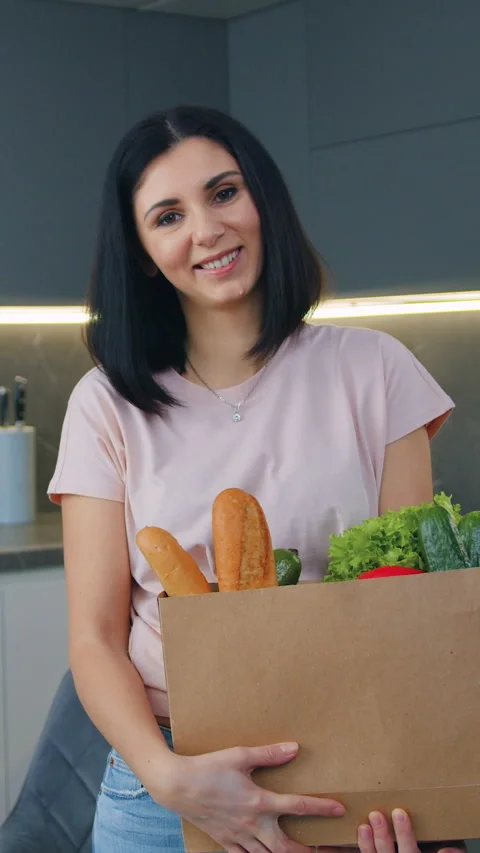 Good-looking smiling satisfied 30-aged brunette posing on camera with products p Stock Footage 330064891