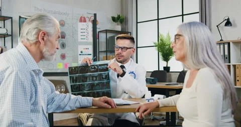 Good-looking smiling successful skilled bearded doctor showing results-of x-ray Stock Footage 160758802