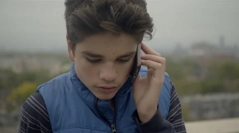Good looking teenage boy talking on his smart phone outside. 4K UHD. Stock Footage 68198341