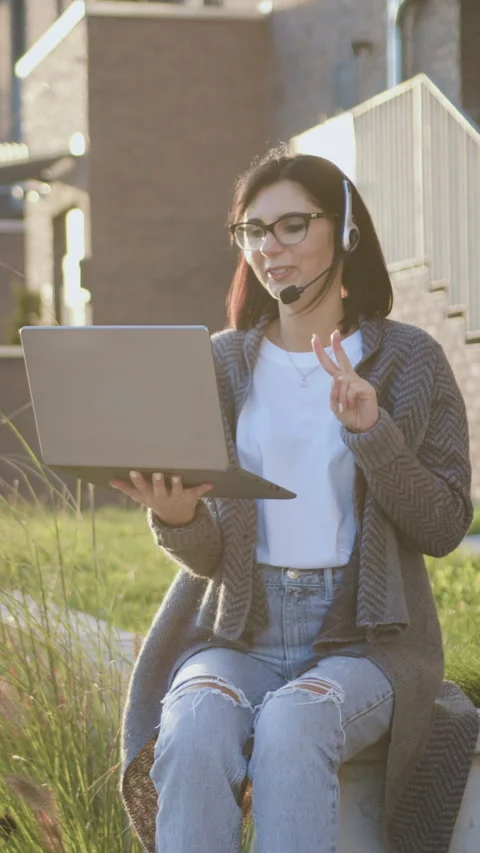 Good-looking woman using computer laptop with headset talking on video call look Stock Footage 328594839
