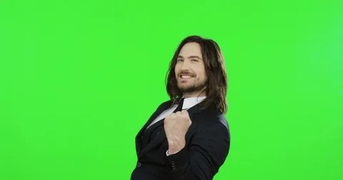 Good looking young cheerful businessman in the black suit and tie pointed with Video stock 90010153