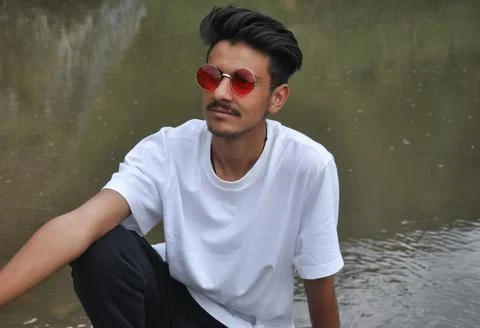 A good looking young guy sitting beside of river  Stock Photos