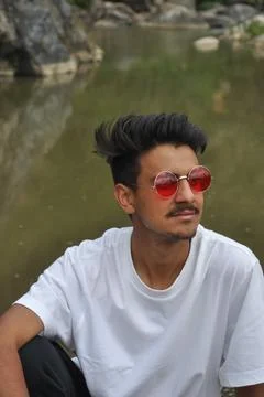 A good looking young guy sitting beside of river  Stock Photos