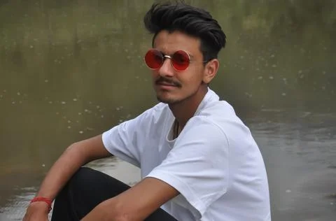 A good looking young guy sitting beside of river  Foto stock