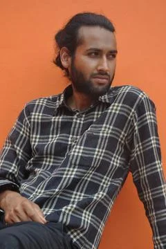 A good looking young man with beard and hair bun looking sideways  Stock Photos
