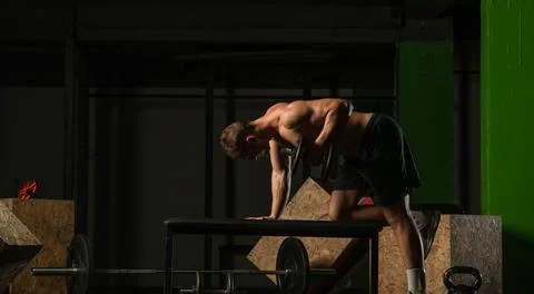 Good looking young man doing triceps dumbbell kickback exercises with his lef Stock Photos