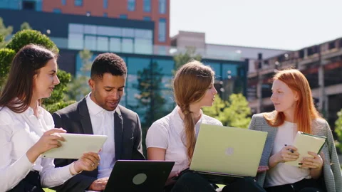 Good looking young office team working together on the laptops and tablets in Stock Footage 194414840