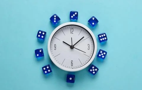 Good luck time. White clock with dice on blue background. Top view. Flat lay Stock Photos