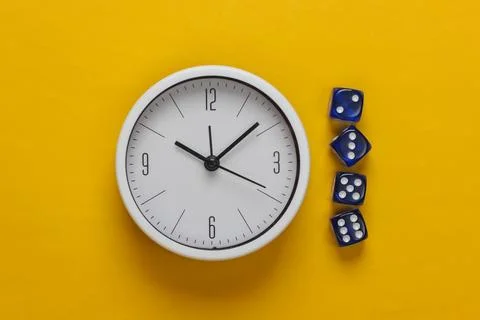 Good luck time. White clock with dice on yellow background. Top view. Flat la 库存照片