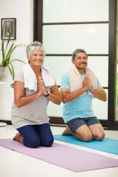 Good for the mind and body. Portrait of a mature couple doing yoga together at Stock Photos