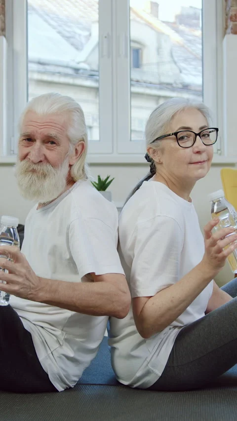Good-natured balanced active mature bearded man and woman in sportswear relaxing Stock Footage 329771799