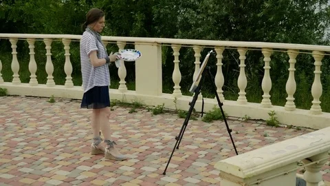 Good painter. A landscape female painter painting a picture with oil paints. 4K Video stock 78785231