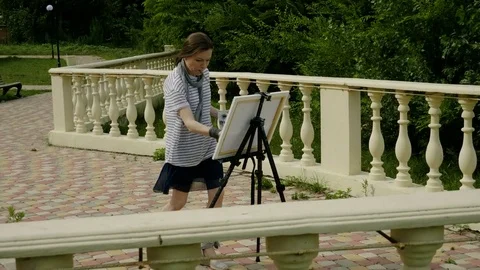 Good painter. A landscape female painter painting a picture with oil paints. 4K Video stock 79076854