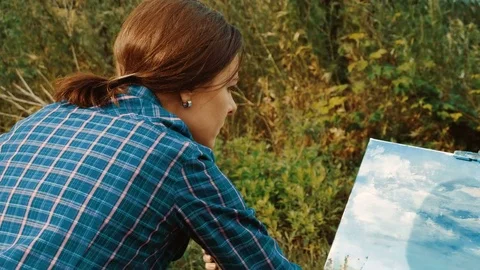 Good painter. A landscape female painter painting a picture with oil paints. 4K 库存影片 79365895