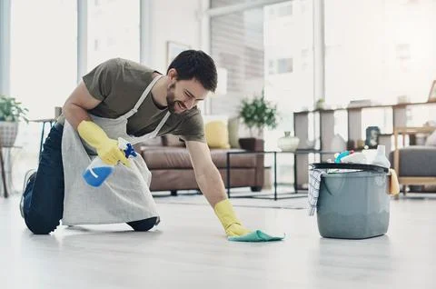 A good scrub gets rid of dirt and grub. a young man wiping the floor at home. Stock Photos